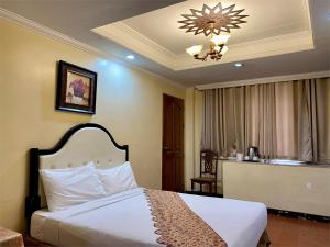 una camera d'albergo con letto e lampadario a braccio di White Knight Hotel Intramuros a Manila