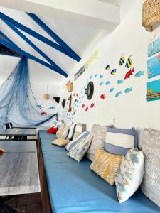 een kamer met een lang blauw bed met kussens bij Pension Hibiscus Taha'a in Vaitoare