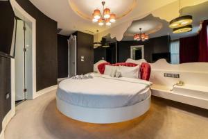 a large bedroom with a large white bed with red chairs at Golden Pars Hotel in Bursa