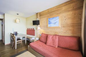 a living room with a red couch and a table at Résidence L'Ours Blanc - maeva Home - Studio 5 pers Confort MAE-5828 in LʼHuez
