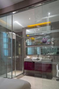 a bathroom with a glass shower and a sink at Golden Pars Hotel in Bursa