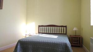 1 dormitorio con 1 cama con edredón azul en Gîte de France à Lignareix 2 épis - Gîte de France 8 personnes 224, en Lignareix