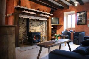 a living room with a fireplace and a table at Gîte de France Pierrelise 3 épis - Gîte de France 8 personnes MAE-9194 in Espartignac