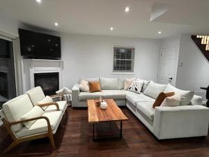 Sala de estar con sofá blanco y mesa de centro en Modern lakehouse southside lake simcoe, en Brechin