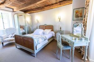 a bedroom with a bed and a table and a mirror at Gîte de France Le clos du bournazel 4 épis - Gîte de France 4 personnes MAE-9254 in Albignac