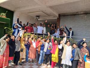 um grupo de pessoas posando para uma foto com as mãos no ar em Abrol residency em Katra