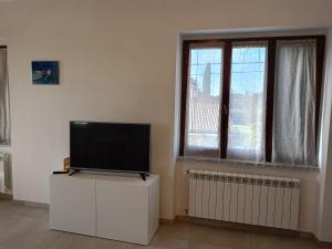 una sala de estar con TV de pantalla plana en una cómoda en Avenza Dream, en Carrara