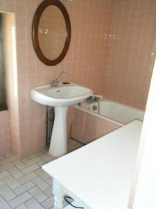a bathroom with a sink and a mirror and a tub at Gîte de France à Juillac ( correze) 2 épis - Gîte de France 5 personnes MAE-9274 in Juillac