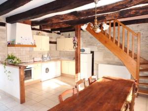 een keuken met een houten tafel en een trap bij Gîte de France à Turenne 3 épis - Gîte de France 6 personnes 334 in Turenne