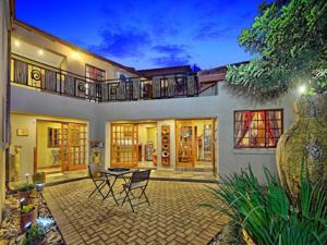 a house with a patio with a table and chairs at Amakoekoe Guest Lodge & Conference Venue in Johannesburg