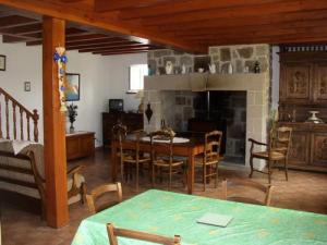 uma sala de estar com uma mesa e uma lareira em Gîte de France à Sarroux - St Julien 3 épis - Gîte de France 6 personnes 414 em Sarroux