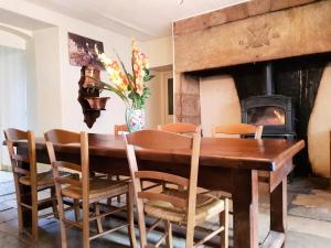 une salle à manger avec une table en bois et une cheminée dans l'établissement Gîte de France à Chasteaux 2 épis - Gîte de France 4 personnes 364, à Chasteaux