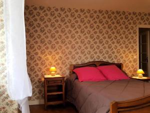 - une chambre avec un lit avec des oreillers roses et 2 lampes dans l'établissement Gîte de France à Chasteaux 2 épis - Gîte de France 4 personnes 364, à Chasteaux