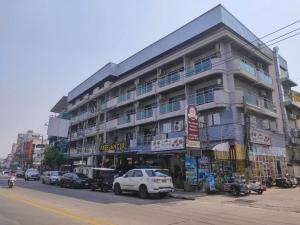 a large building with cars parked in front of it at The Freelancer Hotel in Pattaya Central