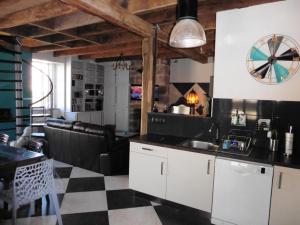 Una cocina con suelo a cuadros en blanco y negro. en Gîte de France Gîte la chapelle avec piscine 3 épis - Gîte de France 6 personnes MAE-9464, en Saint-Solve