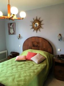 1 dormitorio con 1 cama verde y 2 almohadas en Gîte de France Gîte la chapelle avec piscine 3 épis - Gîte de France 6 personnes MAE-9464, en Saint-Solve 4 fotos más