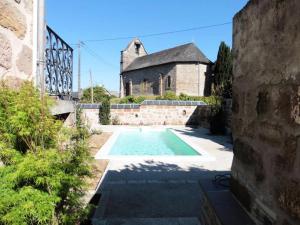 una piscina frente a un edificio con una iglesia en Gîte de France Gîte la chapelle avec piscine 3 épis - Gîte de France 6 personnes MAE-9464, en Saint-Solve