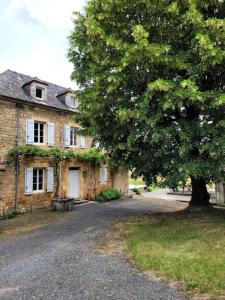 una vieja casa de ladrillo con un árbol delante en Gîte de France De baudran 3 épis - Gîte de France 6 personnes 424 