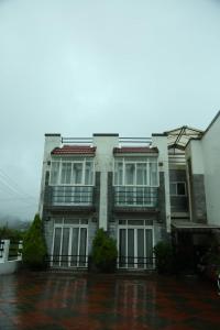 a white house with two balconies on top of it at TAT HOLIDAYS Armaan Groups in Ooty