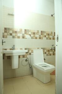 a bathroom with a toilet and a sink at TAT HOLIDAYS Armaan Groups in Ooty