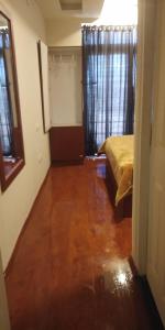 a bedroom with a bed and a wooden floor at TAT HOLIDAYS Armaan Groups in Ooty