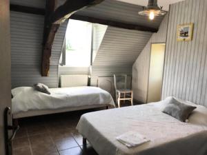 - une chambre avec 2 lits et une fenêtre dans l'établissement Gîte de France "les volets bleus" épis - Gîte de France 484, à Espartignac