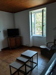 un soggiorno con un divano, un tavolo e una TV di Gîte de France L'hyvernerie 3 épis - Gîte de France 7 personnes MAE-9504 a Gumond Altre 33 foto