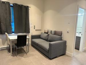 una sala de estar con un sofá y una mesa en A Tiny House Near UBC 温哥华UBC小别墅, en Vancouver