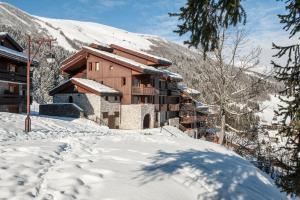 eine Skihütte in den Bergen im Schnee in der Unterkunft Quartier Crève Cœur - maeva Home - Appartement 2 pièces 4 personnes 21 in Valmorel
