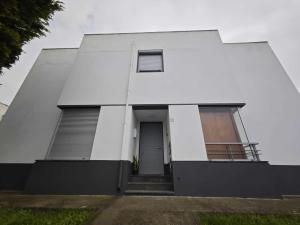 un edificio blanco con puerta y ventana en Luz's Retreat Apartment en Ponta Delgada