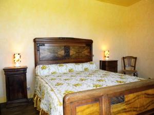 Gîte de France Laclefdeschamps 3 épis - Gîte de France 10 personnes MAE-9514 في Luc: غرفة نوم بسرير ومصباحين وكرسي