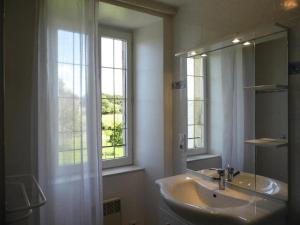 Gîte de France Laclefdeschamps 3 épis - Gîte de France 10 personnes MAE-9514 في Luc: حمام مع حوض ومرآة ونافذة +79 صورة