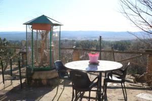 - une table avec des chaises et un nourrisson d'oiseaux sur la terrasse dans l'établissement El Regajo, à Ayora