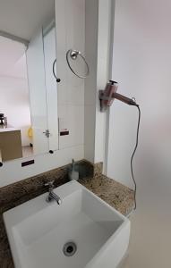 a bathroom with a white sink and a mirror at Studio Top Life: Garagem | Wifi | Ar-condicionado NA1002 in Juiz de Fora
