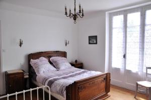- une chambre avec un lit et un lustre dans l'établissement Gîte de France à Soudeilles épis - Gîte de France 574, 