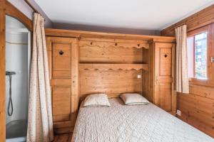 ein Schlafzimmer mit einem Bett mit einem hölzernen Kopfteil in der Unterkunft Résidence Les Fermes du Soleil - maeva Home - Appartement 3 pièces 6 personnes Sélection MAE-1439 in Les Carroz d'Araches + 28 Fotos