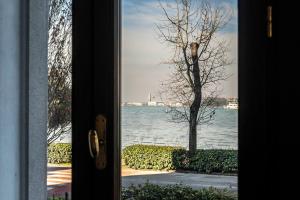 a door view of the water through a window at Palazzo Boito Luxury Apartment on Lido with Venice view in Venice-Lido