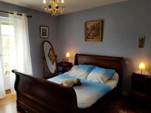 een slaapkamer met een bed, een spiegel en een kroonluchter bij Gîte de France à Albussac 3 épis - Gîte de France 2 personnes 614 in Albussac