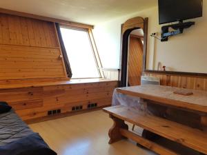 une pièce avec un banc et une grande fenêtre dans l'établissement Résidence Les Arolles - Apartement 2 pièces 6 personnes à Arc 1600 en centre station et proche des pistes MAE-1701, à Arc 1600