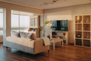 sala de estar con sofá y TV de pantalla plana en Piso en Puerto de Altea, en Altea
