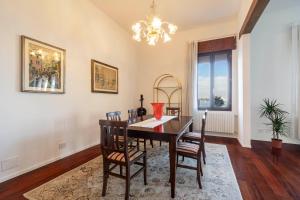 a dining room with a table and chairs and a chandelier at Palazzo Boito Luxury Apartment on Lido with Venice view in Venice-Lido +19 photos