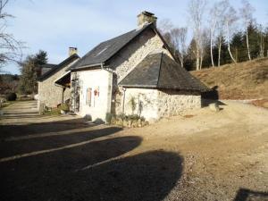 un pequeño edificio de piedra con techo negro en Gîte de France à Chaveroche 2 épis - Gîte de France 2 personnes 664, 