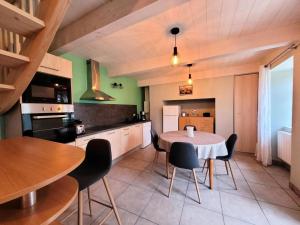 une cuisine avec une table et des chaises dans une pièce dans l'établissement Gîte de France La maison de thienot 3 épis - Gîte de France 3 personnes MAE-9724, à La Bitarelle 24 autres photos