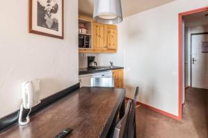 a kitchen with a wooden table and a telephone at Résidence Quartier Falaise - maeva Home - Appartement 2 pièces 4 personnes Sélection MAE-2593 in Avoriaz