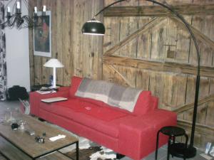 a red couch in a living room with a wooden wall at Chalet belle vue montagne proche Valmorel 86009 in Valmorel