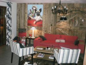 a living room with a red couch and a table at Chalet belle vue montagne proche Valmorel 86009 in Valmorel