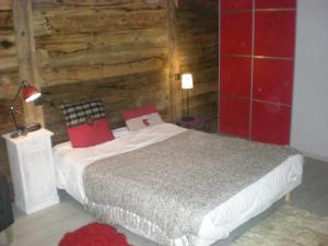 a bedroom with a bed and a wooden wall at Chalet belle vue montagne proche Valmorel 86009 in Valmorel