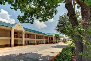 an exterior view of a building with trees at Motel 6-Arlington, TX in Arlington