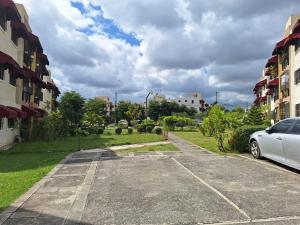 une voiture garée dans un parking entre deux bâtiments dans l'établissement Bello Apartamento, 2 habitaciones 2 baños Santo Domingo Carmen Renata III, à Saint-Domingue