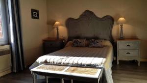 a bedroom with a bed with a large headboard at Gîte de France à Lagleygeolle 3 épis - Gîte de France 4 personnes MAE-9734 in Lagleygeolle